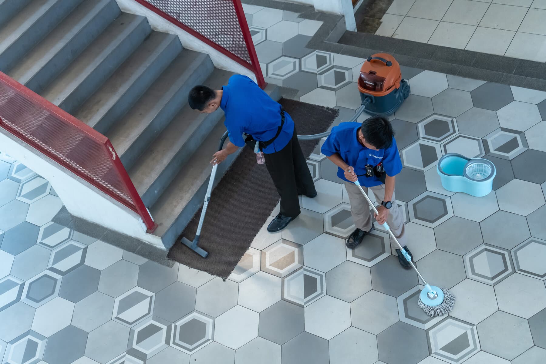 Tim office boy dan cleaning service bertugas membersihkan tangga dan lobi