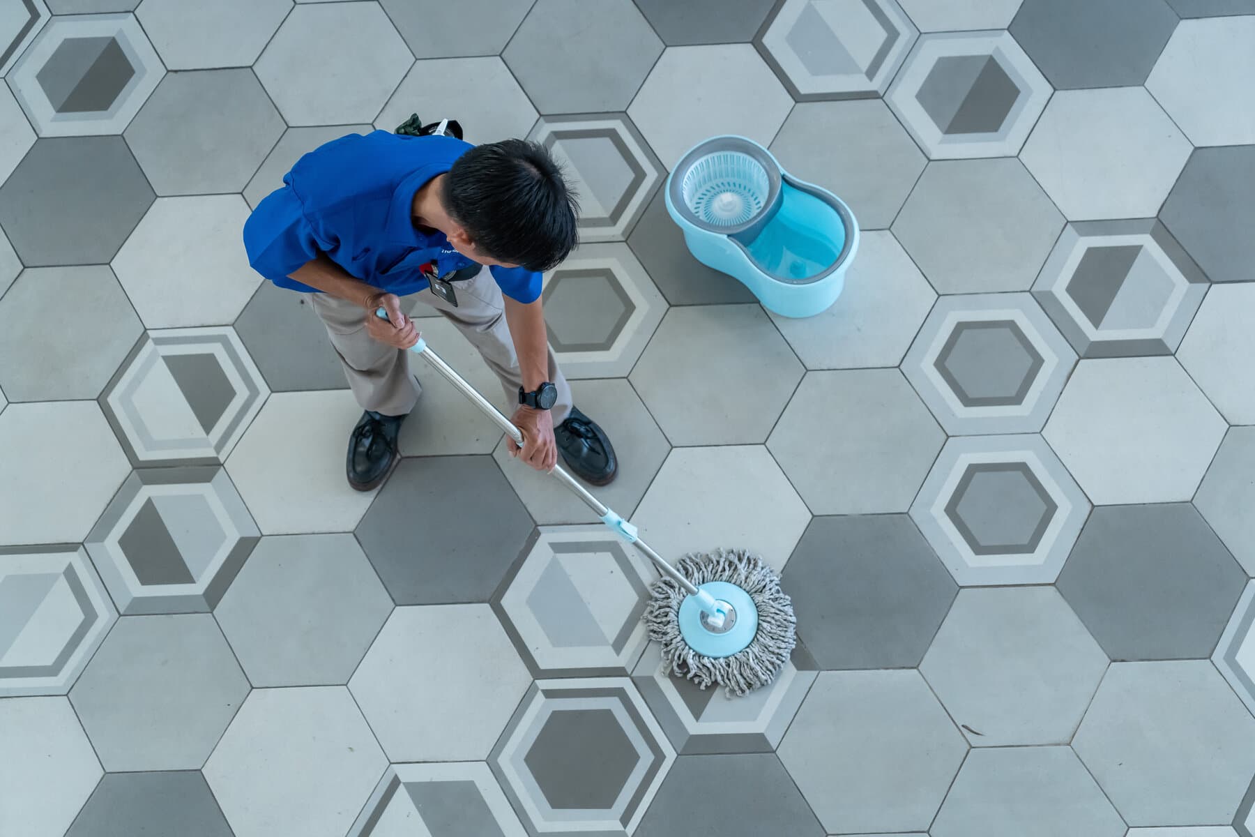 Petugas cleaning service mengepel lantai kantor