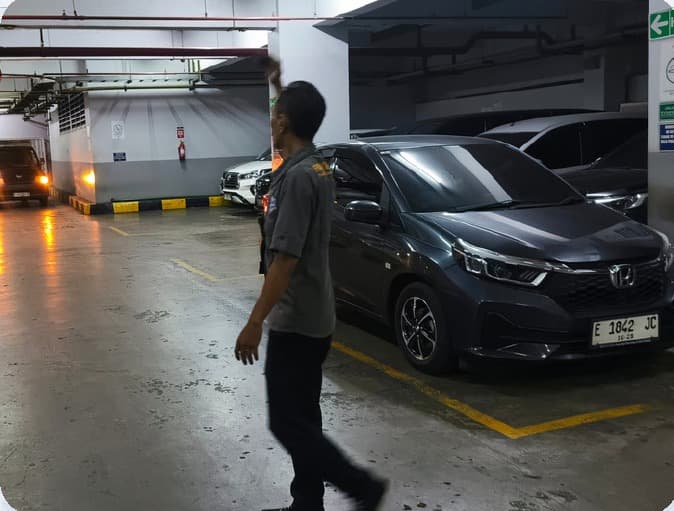 Petugas berpatroli mengawasi area parkir
