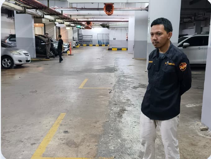 Petugas mengawasi kelancaran arus kendaraan di area parkir