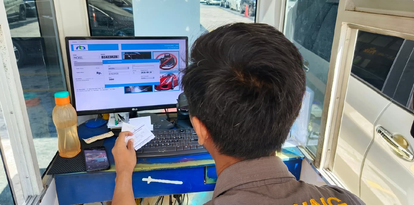 Petugas memproses transaksi parkir cashless di pos jaga